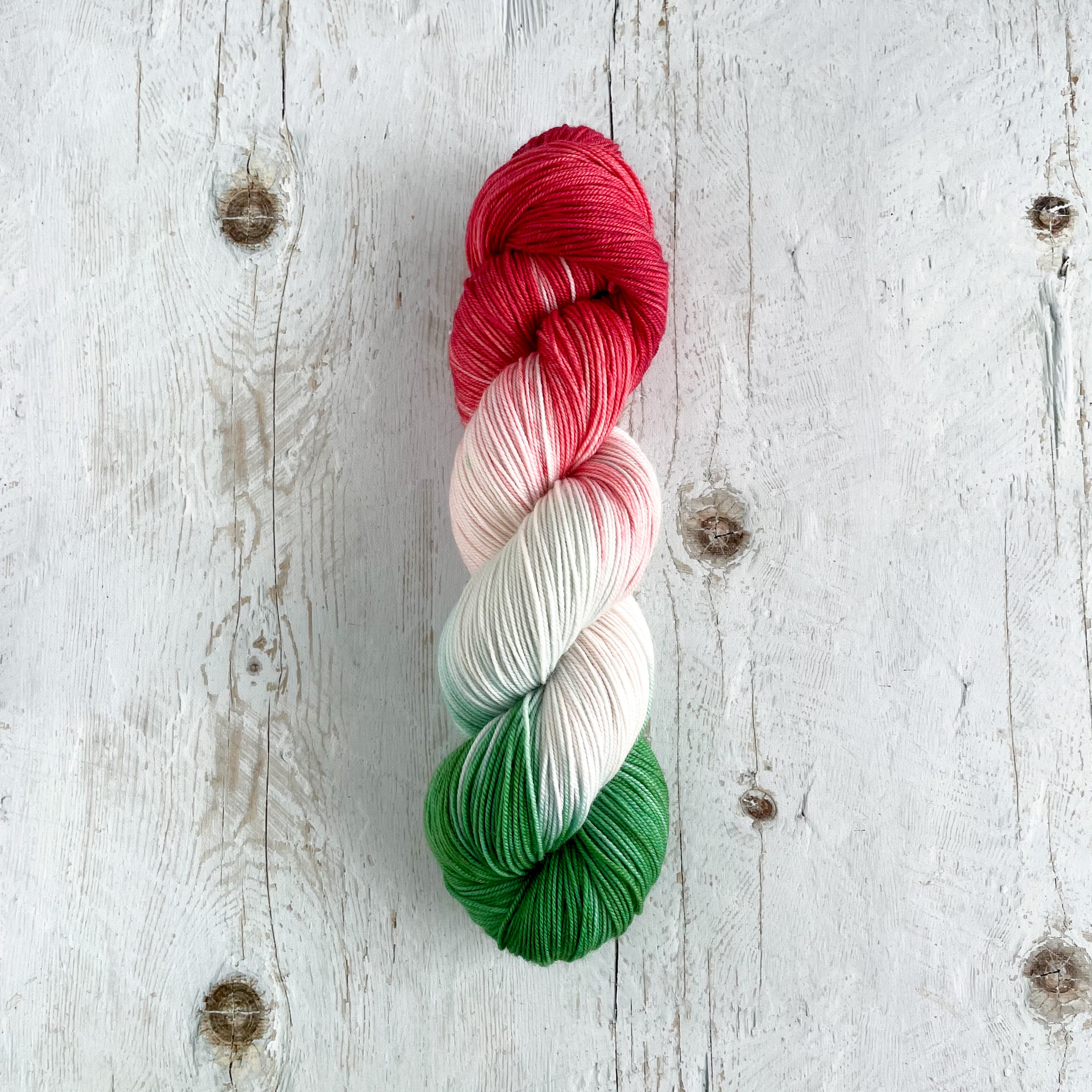 Multicolored skein of yarn on a wooden surface (Hungarian flag colors)